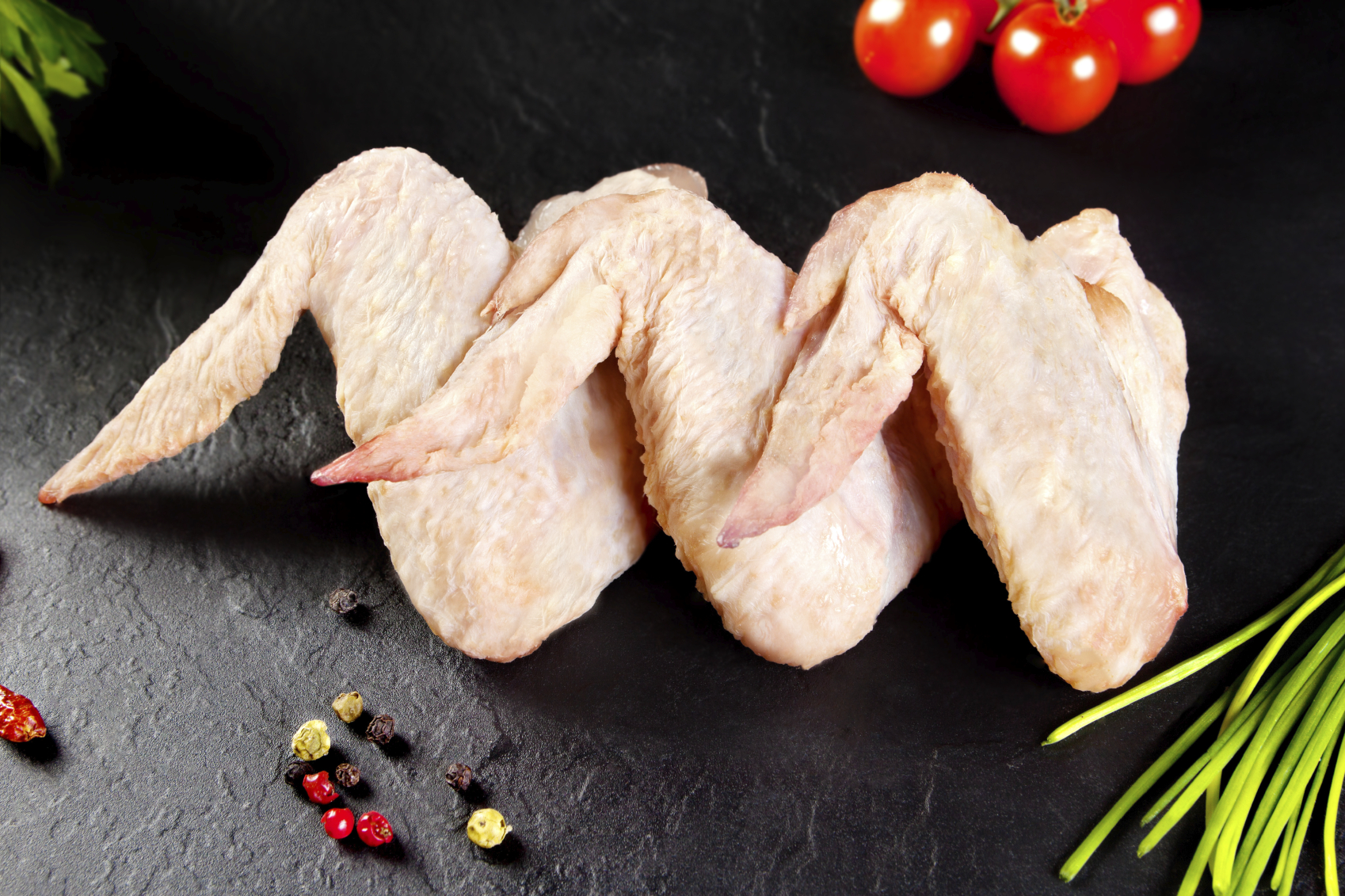 Fresh and raw meat. Chicken wings white  ready to cook. Background black blackboard